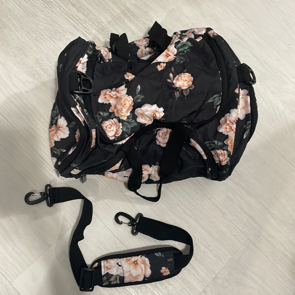 Regular size black luggage bag with flowers all over.